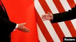 Presiden AS Donald Trump dan Presiden ChinaXi Jinping berjabat tangan setelah membacakan pernyataan bersama di Aula Besar Rakyat, di Beijing, China, 9 November 2017. (Foto:dok)