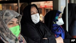 Commuters wear masks on a public bus in downtown Tehran, Iran, Feb. 23, 2020. Iran's Health Ministry raised the death toll from the new coronavirus to eight people in the country.