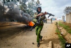 FILE - FILE - A riot policeman reloads a teargas grenade launcher during clashes with protesters in the Kibera area of Nairobi, Kenya on July 19, 2023.