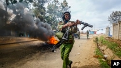 FILE - A riot policeman reloads a teargas grenade launcher during clashes with protesters in the Kibera area of Nairobi, Kenya on July 19, 2023. 