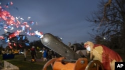 A confetti canon is launched at the Krewe de Jeanne d'Arc drive-thru parade in Behrman Memorial Park in Algiers for the start of Twelfth Night in New Orleans on Wednesday, Jan. 6, 2021. (Chris Granger/The Times-Picayune/The New Orleans Advocate via AP)