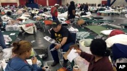 Alain Cisneros, a community organizer for the Immigrant Families and Students in the Struggle, an advocacy group known by its Spanish acronym FIEL, counsels Harvey evacuees who are in the country illegally at the George R. Brown Convention Center in Houston.