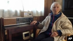 In this photo taken on Sunday, Jan. 8, 2017, 98-year-old Judith Haaland sits next to her decades-old radio set in Stavanger, Norway. In a move likely to be watched closely by other countries, the Norwegian government will begin shutting off the FM signal on Jan. 11, 2017.