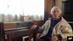 In this photo taken on Sunday, Jan. 8, 2017, 98-year-old Judith Haaland sits next to her decades-old radio set in Stavanger, Norway.