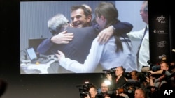 Celebrating scientists in the main control room appear on a video screen at the European Space Agency after the first unmanned spacecraft Philae landed on a comet called 67P/Churyumov-Gerasimenko, in Darmstadt, Germany, Nov. 12, 2014.