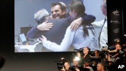 Scientists celebrate at the European Space Agency after the first unmanned spacecraft Philae landed on a comet called 67P/Churyumov-Gerasimenko on Nov. 12, 2014. (AP Photo/Michael Probst)