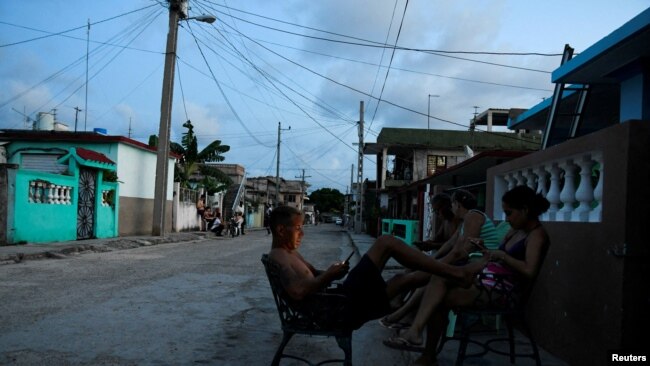 Falla en red eléctrica de Cuba sume al país en la oscuridad 1 ARCHIVO - Personas sentadas afuera de sus casas durante un corte de energía causado por averías que obligaron a seis plantas a desconectarse de la red, según la compañía eléctrica estatal, en Matanzas, Cuba, el 22 de agosto de 2024. REUTERS/Norlys Perez.