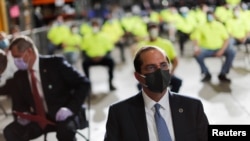 Health and Human Services Secretary Alex Azar sits in the front row as President Donald Trump speaks to employees during a visit to a medical equipment distributor in Allentown, Pa., May 14, 2020. 