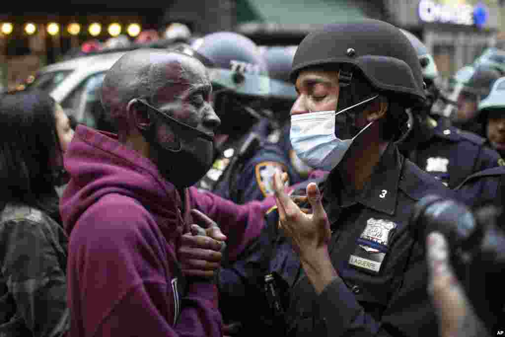 A protester and a police officer shake hands during a solidarity rally in New York, calling for justice over the death of George Floyd, June 2, 2020.&nbsp;Floyd died after being restrained by Minneapolis police officers on May 25.&nbsp;