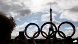 FILE: The Olympic rings are set up on Trocadero plaza that overlooks the Eiffel Tower, a day after the official announcement that the 2024 Summer Olympic Games will be in the French capital, in Paris, France, Thursday, Sept. 14, 2017. 