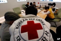 South Koreans who were separated from their families during the Korean War, talk with Red Cross members as they check application forms to reunite with their family members living in North Korea, at the Korea Red Cross headquarters in Seoul, South Korea,