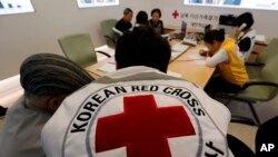 South Koreans who were separated from their families during the Korean War, talk with Red Cross members as they check application forms to reunite with their family members living in North Korea, at the Korea Red Cross headquarters in Seoul, South Korea, 