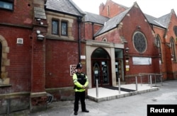 FILE - A police officer stands outside Didsbury mosque in Manchester, Britain, May 24, 2017.