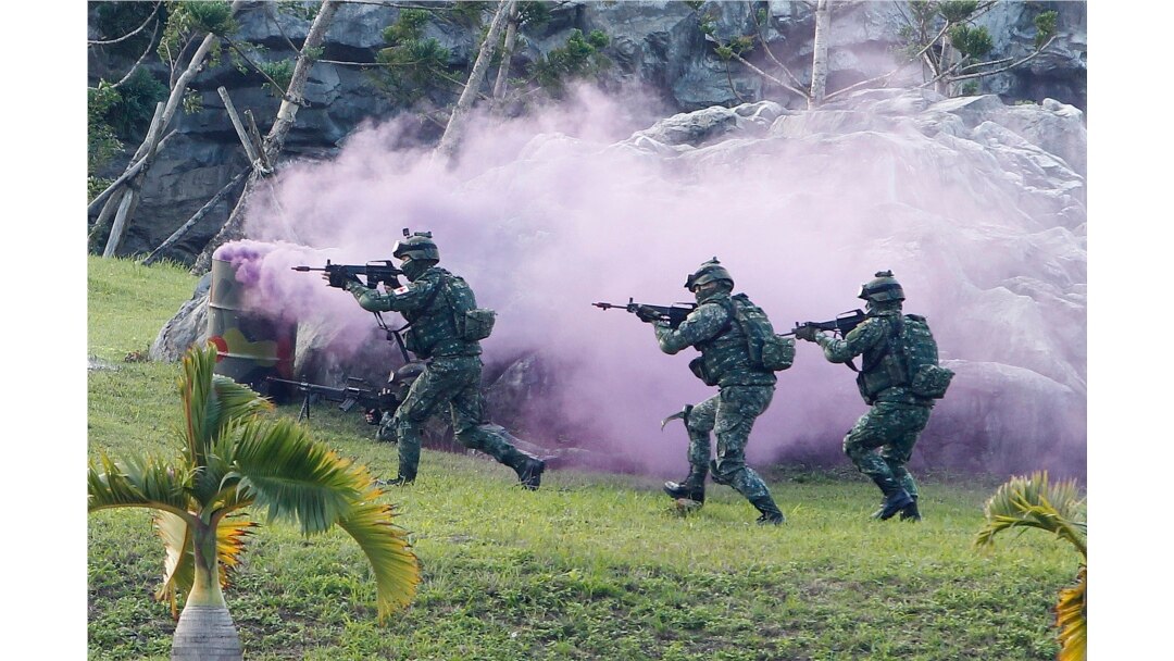 FILE - Soldiers from Taiwan's special forces move past colored smoke during a helicopter landing training and all-out defense demonstration in Taipei, Taiwan, Dec. 14, 2017.