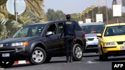 A Senegalese police officer conducts a vehicle inspection at the entrance of a Dakar hotel, Jan. 22, 2016. Security measures have been reinforced close to public buildings, following jihadist attacks in Bamako and Ouagadougou.