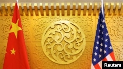 FILE - Chinese and U.S. flags are set up for a meeting in Beijing, April 27, 2018. 