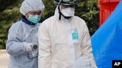 Emergency workers checking each other for radiation exposure in Koriyama, Japan, March 13, 2011