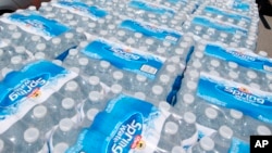 FILE - Cases of bottled water distributed to people, in Oceanport, N.J., June, 30, 2012. 