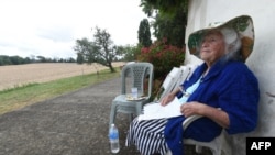 FILE - Genevieve Callerot, 102, sits in the garden of her farm, on Aug. 25, 2018, in Saint-Aulaye, southwestern France. 