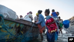 Tigray refugees arrive on the banks of the Tekeze River on the Sudan-Ethiopia border, in Hamdayet, eastern Sudan, Dec. 2, 2020.