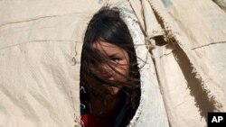 یک دختر افغانستانی در چادر اردوگاه پناهندگان در حومه مزار شریف، یکی از هزاران افغانستانی که از ترس طالبان از خانه‌هایشان فرار کرده‌اند