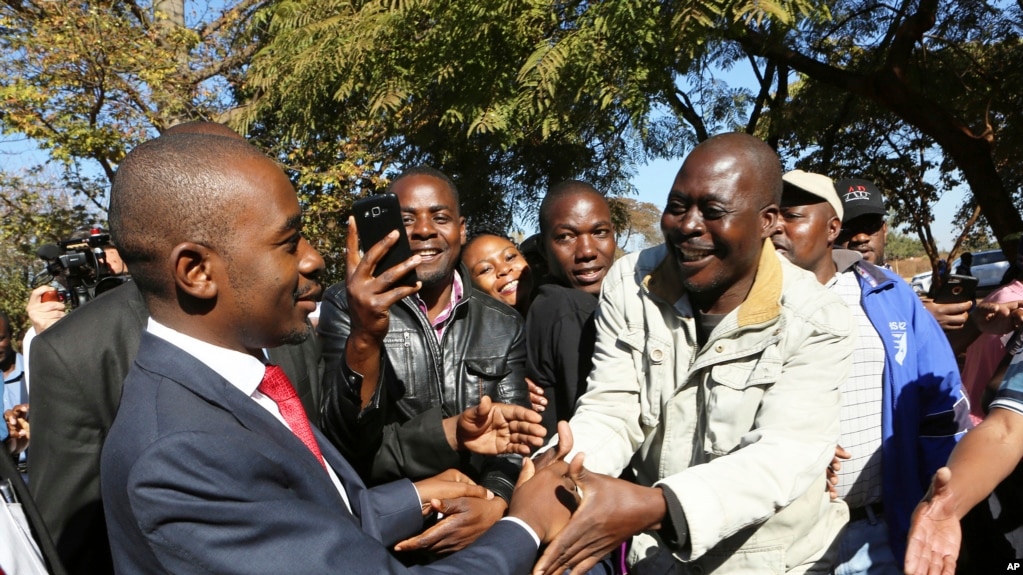 Le chef de l'opposition zimbabwéenne Nelson Chamisa, à gauche, salue les sympathisants après avoir voté dans un bureau de vote à Harare, au Zimbabwe, lundi 30 juillet 2018.(AP Photo / Tsvangirayi Mukwazhi)