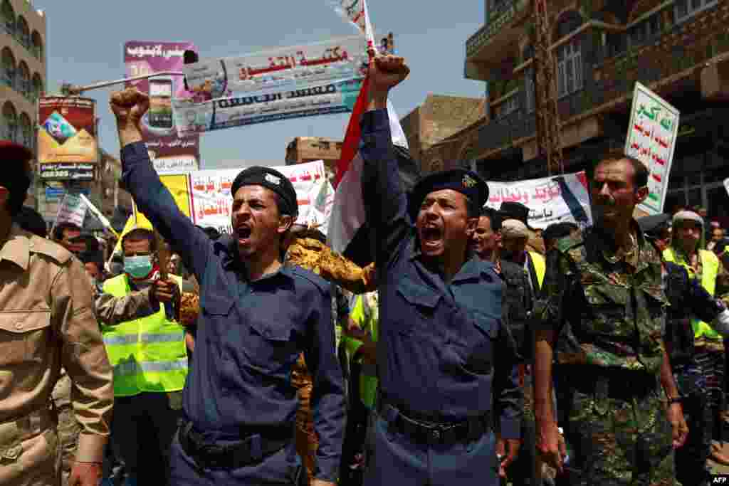 Pasukan keamanan pendukung demonstran Syiah Houthi ikut berteriak dalam demo anti pemerintah di Sanaa.