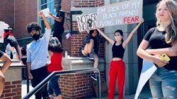 Natasha Dhamavasi (second from right), Archawee Dhamavasi's daughter, holds a banner during a Black Lives Matter protest in Downers Grove village, Illinois on June 7, 2020