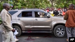 Onlookers gather at the scene after Kenyan lawmaker George Muchai, his two bodyguards and driver were shot dead on a main street in Nairobi, Kenya, Feb. 7, 2015. 