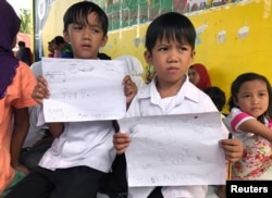 Evacuated students show their drawings about what they and other Marawi residents experienced before fleeing the city still under siege during a school day at Pantar elementary school in Lanao Del Norte, Philippines, June 6, 2017.