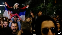 A protester holds a Serbian flag during a protest march in Belgrade, Serbia, April 5, 2017. Several thousand mostly young people have rallied for the third day against the victory of Serbia's powerful Prime Minister Aleksandar Vucic at last weekend's presidential election, claiming the vote was rigged.