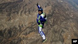 In this Monday, July 25, 2016 photo, skydiver Luke Aikins smiles as he jumps from a helicopter during his training in Simi Valley, Calif. 