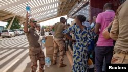 Citizens evacuated from Niger at the Diori Hamani International Airport in Niamey