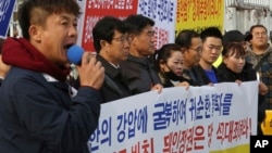 North Korean defectors stage a rally denouncing the deportation of North Korean fishermen in Seoul, South Korea, Nov. 12, 2019. The sign reads: "Apologize for the government of Moon Jae-in who deported the defectors." 