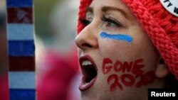 Kelly Duncan menulis slogan "Gone 2020" di pipinya, saat berpartisipasi dalam Pawai Tahunan "Women's March" di Washington DC, 20 Januari 2018. (Foto: dok).