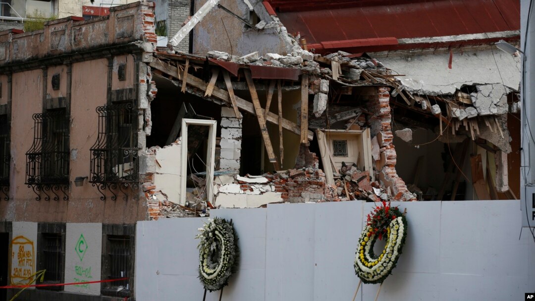 Funeral wreaths stand in front of the lot where a chemical laboratory collapsed, heavily damaging two adjacent buildings, in the Roma Norte area of Mexico City, Oct. 1, 2017.