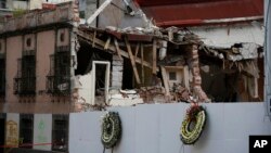 Funeral wreaths stand in front of the lot where a chemical laboratory collapsed, heavily damaging two adjacent buildings, in the Roma Norte area of Mexico City, Oct. 1, 2017.