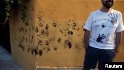 FILE - These handprints are from black paint for Spain's Black Paint Festival September 6, 2019. ( REUTERS/Jon Nazca)