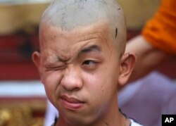 Pornchai Kamluang, his coach, and his teammates who were rescued last week from a flooded cave have their heads shaved in a traditional Buddhist ceremony in Mae Sai district, Chiang Rai province, northern Thailand, Tuesday, July 24