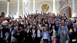 Opposition legislators pose for a group photo on the steps of the National Assembly entrance, after attending their swearing-in ceremony, in Caracas, Venezuela, Tuesday, Jan. 5, 2016. Venezuela's opposition was sworn in as the majority during a heated parliamentary session that saw pro-government representatives walk out in protest after pushing and shoving their way onto the dais as the new leadership laid out its legislative agenda. (AP Photo/Fernando Llano)