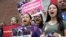 Protesters display placards and chant slogans, Aug. 14, 2019, while gathered outside federal court, in Boston. The demonstration was held to protest the Trump administration's campaign to end temporary protected status.