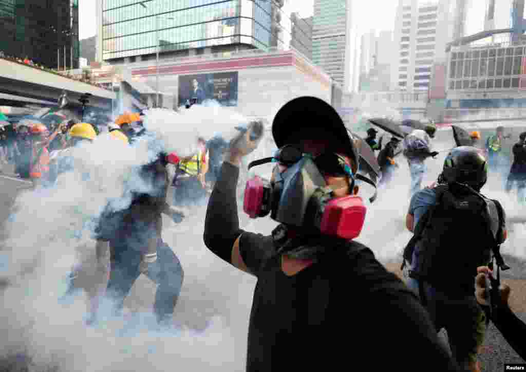 一名香港反送中抗议者在政府总部附近把警察射出的催泪弹扔回警察。（2019年9月15日）