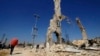 A picture of Syria's President Bashar al-Assad is displayed on a damaged structure at the entrance of al-Dukhaneya neighborhood near Damascus, October 7, 2014