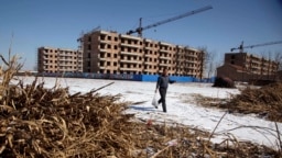 資料--一名中國農民走過河北省大麻子莊給拆遷農民建造的樓房(2011年2月11日)
