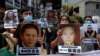 香港示威者在中联办前手举中国维权律师和异议人士的照片抗议国安法。（2020年6月25日）