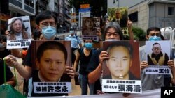 香港示威者在中联办前手举中国维权律师和异议人士的照片抗议国安法。（2020年6月25日）