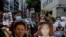 Pro-democracy demonstrators hold up portraits of jailed Chinese civil rights activists, lawyers and legal activists as they march to the Chinese liaison office in Hong Kong, Thursday, June 25, 2020. They demand to abolish the national security law…