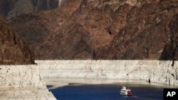 FILE - A riverboat glides through Lake Mead on the Colorado River at Hoover Dam near Boulder City, Nev., Oct. 14, 2015. The Bureau of Reclamation is forecasting first-ever water shortages because of falling levels at Lake Mead.