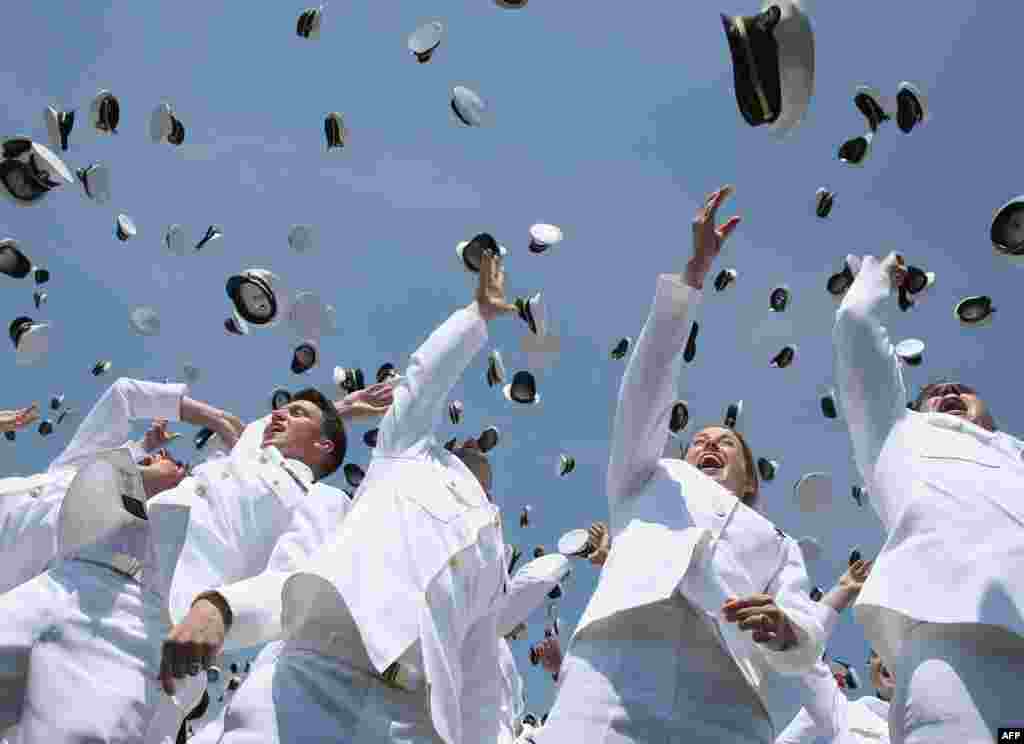 U.S. Naval Academy graduates toss their hats in the air during graduation ceremonies at the U.S. Naval Academy in Annapolis, Maryland.
