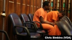 Defendants in orange prison jumpsuits and handcuffs wait for Judge Jeri Cohen’s determination of whether they should go back to jail or be placed in a treatment program. The defendants were arrested in Miami, Fla., on charges of using and possessing drugs.